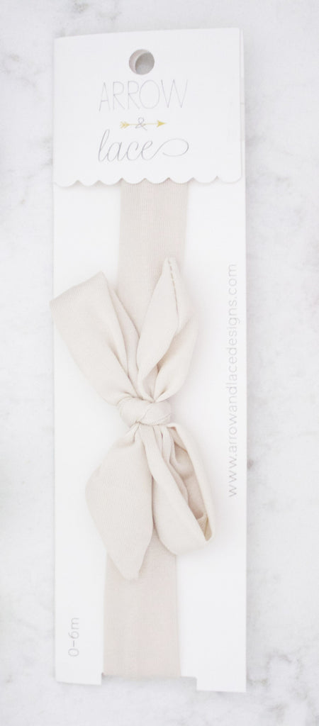 Beige headband in packaging on a white background