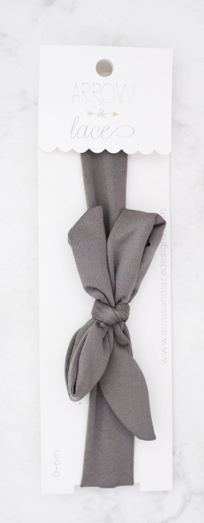 Gray hair tie on a white card with  branding