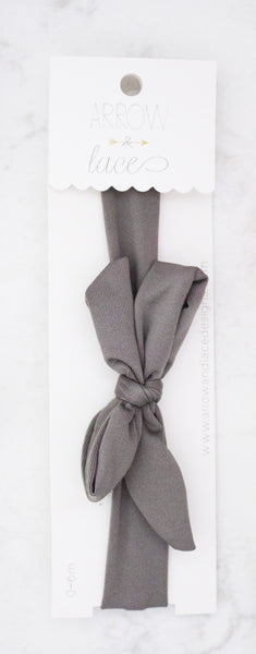 Gray hair tie on a white card with  branding