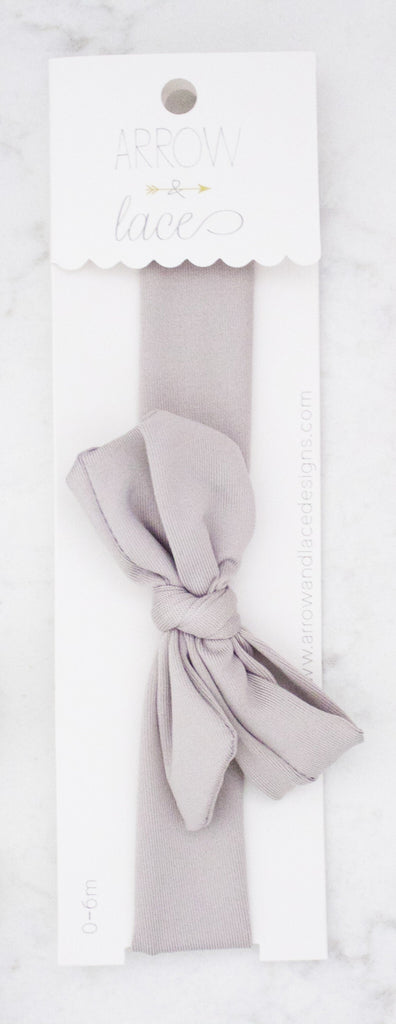 Light gray hair bow in packaging on a white background