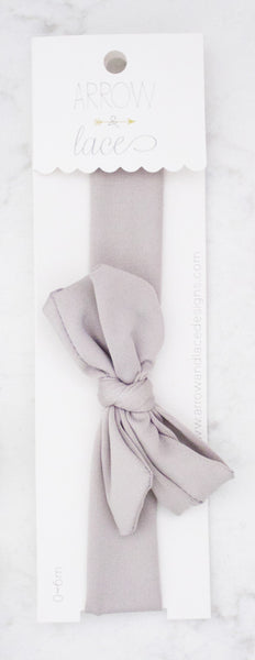 Light gray hair bow in packaging on a white background