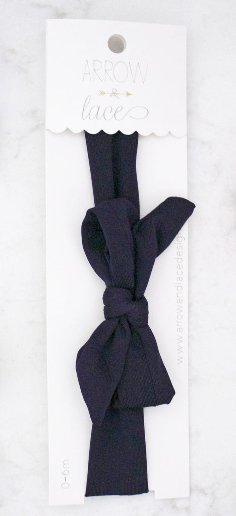 Navy blue bow headband on a white background