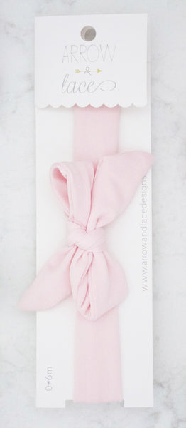 Pink headband with a bow on a white background