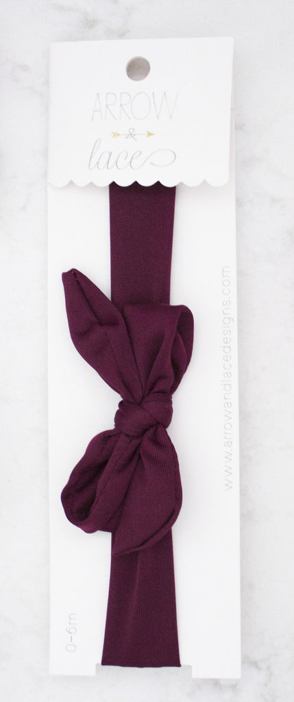Maroon headband with a bow on a white background