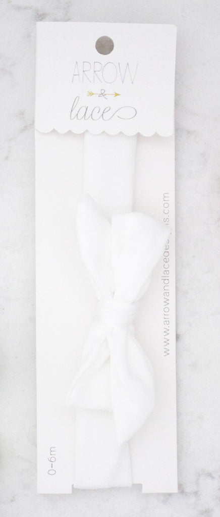White lace trim packaging with  branding on a marble surface